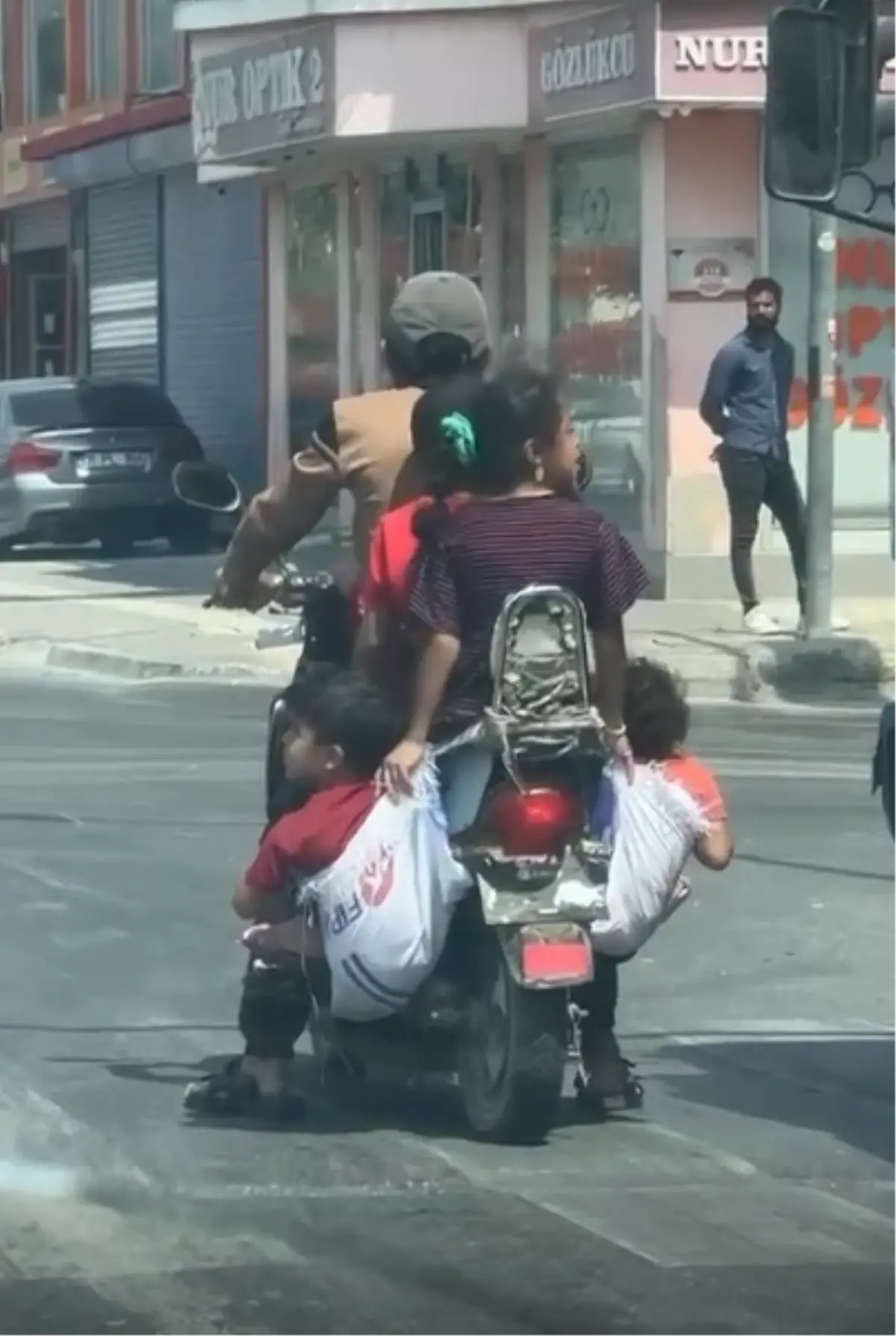 Ölümüne rahatlık! Çocuklarını motosiklete astığı çuvallara koydu